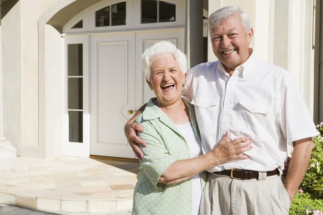 Happy senior couple outside their beautiful home Happy senior couple outside their beautiful home